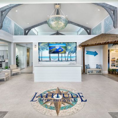 Entrance with large Latitude logo on floor and beautiful  glass light above