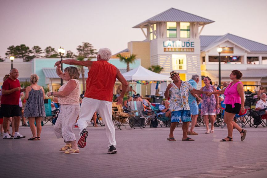 People dancing in the town square of Latitude Margaritaville Watersound.