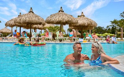 Woman having fun in the pool with a floatie. Latitude Margaritaville Watersound, a 55+ retirement community near Panama City Beach.
