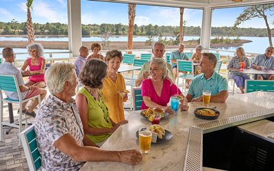 Retired couple sitting down in a park at Latitude Margaritaville Watersound
