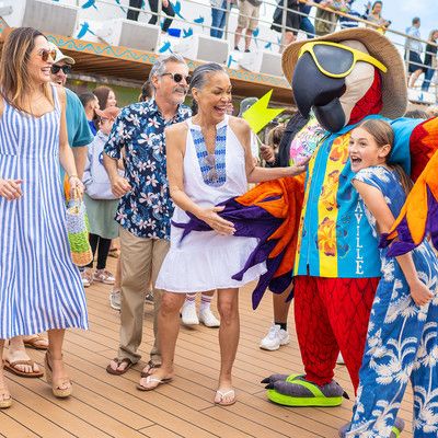 Family having fun and laughing with parrot mascot
