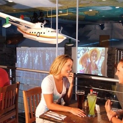 Guests sitting at a table with drinks under a decorative suspended airplane