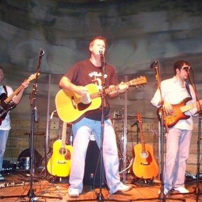Live band performing with acoustic guitar and bass on stage