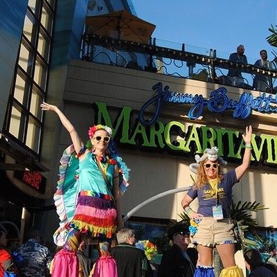 Stilt walker and performer waving outside in front of the Margaritaville sign