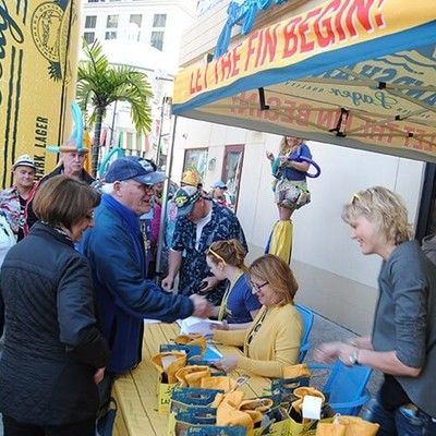 Guests checking in at an outdoor registration table under a LandShark tent