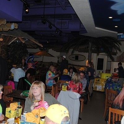 Guests enjoying food and drinks at tables during an indoor party