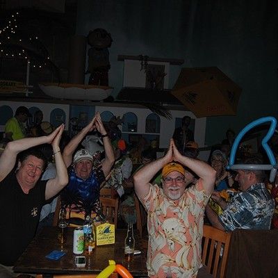 Group of people making shark fin hand signs over their heads during a party