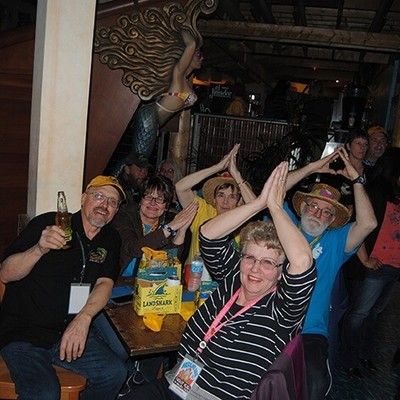 Party guests making shark fin hand gestures while posing at a table