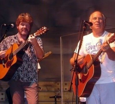Close-up of Jimmy Buffett and guitarist performing together on stage