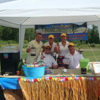 Margaritaville staff posing under a tent setup at a golf tournament