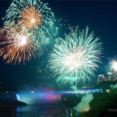 Photo of fireworks display lighting up the night sky over illuminated Niagara Falls