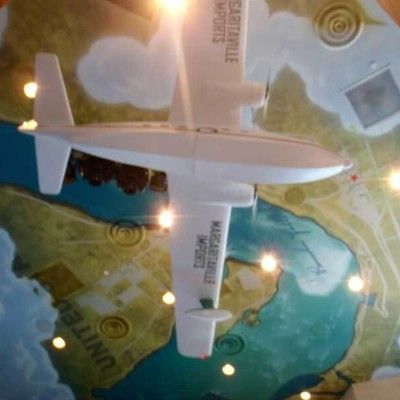 Photo of decorative airplane model mounted on the ceiling over a map design