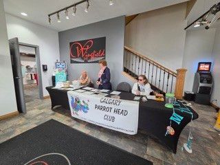 Registration table for the Calgary Parrot Head Club charity event with banners and staff members