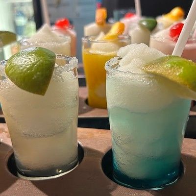 Photo of frozen margaritas garnished with fresh lime slices served on a paddle