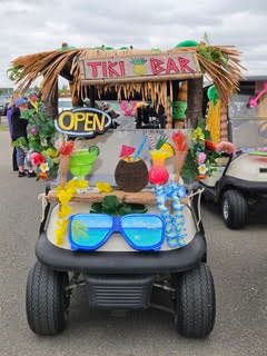 A golf cart decorated as a tropical Tiki Bar with oversized sunglasses and plush toys