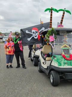 Line of decorated golf carts including a pirate-themed cart with a pirate flag