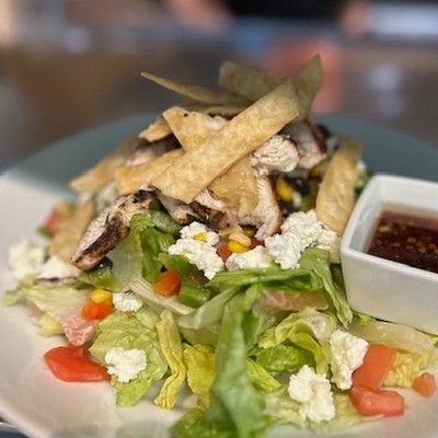 Photo of chicken Cobb salad with feta cheese, tomatoes, and crispy tortilla strips