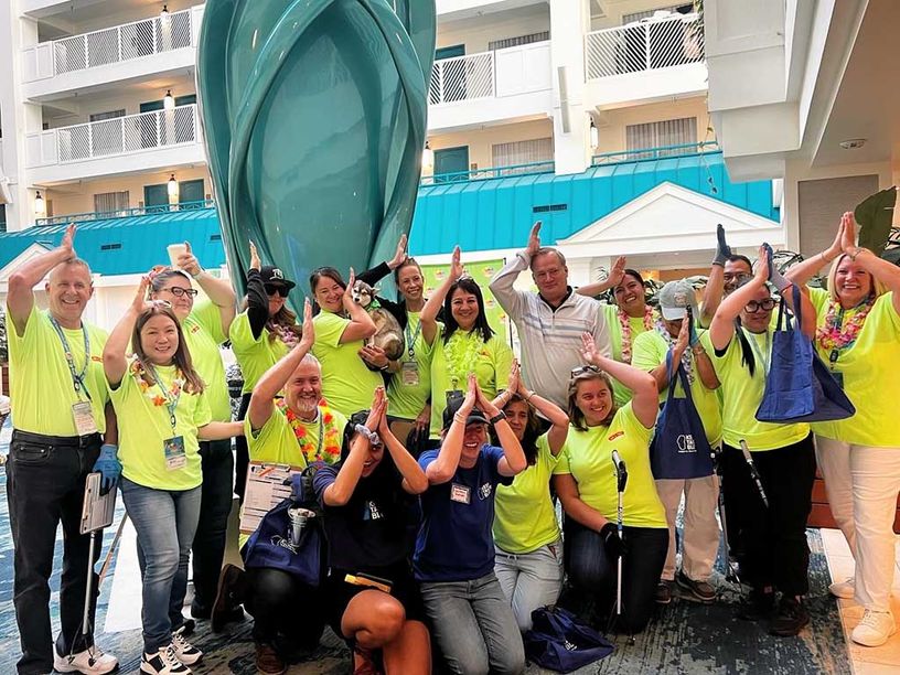 Large group of people having fun doing the fins up sign. This is straight hand over head to represent a fin