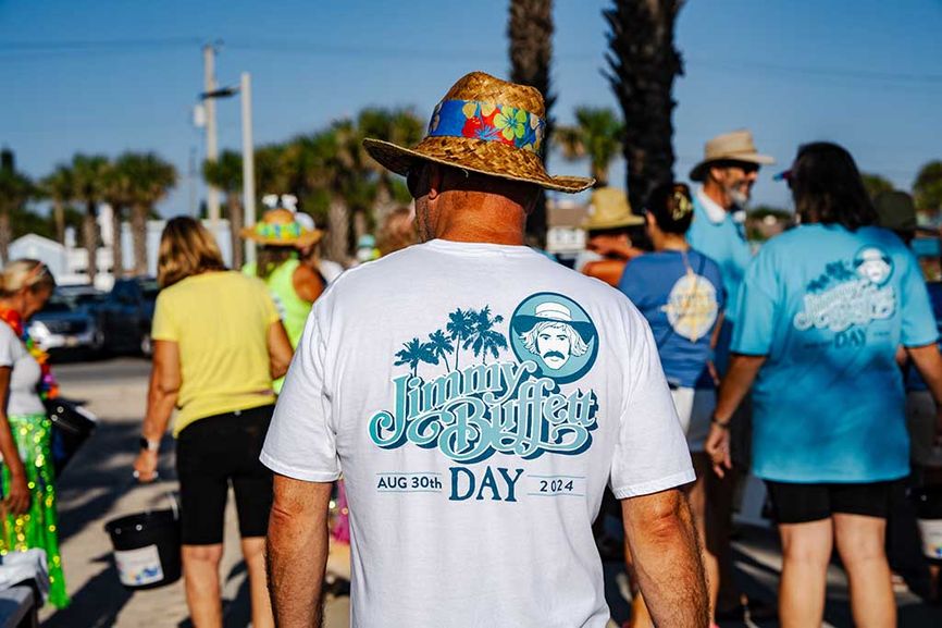 Back of a man wearing a sun hat and a Jimmmy Buffett Day shirt