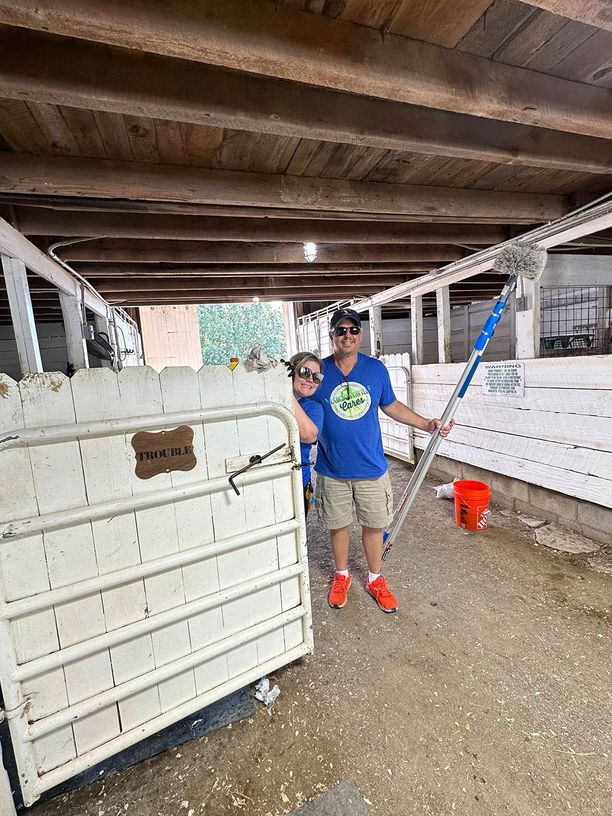 Man and woman about to clean horse stables