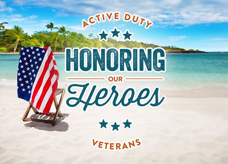 Flag draped over a chair on the beach overlooking water and palm trees
