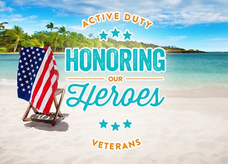 Flag draped over a chair on the beach overlooking water and palm trees