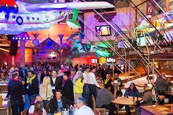Large group of people inside Margaritaville mingling, drinking and eating