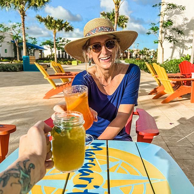 A woman in a sun hat cheersing glasses