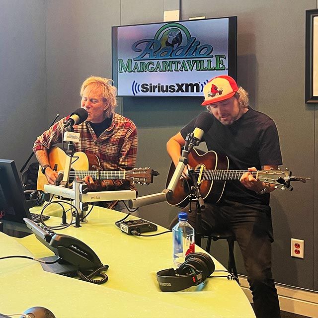 Two guys playing guitar in the studio