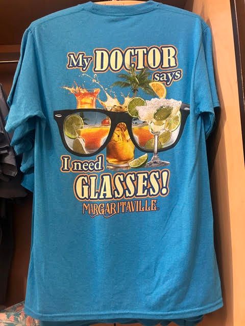 Bright blue t-shirt with tropical drink graphics reading 'My Doctor says I need GLASSES!'