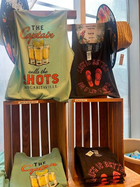 Retail display of green and black Margaritaville tank tops in wooden crates