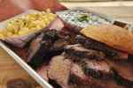 Image of sliced brisket with sides of macaroni and cheese and coleslaw. 