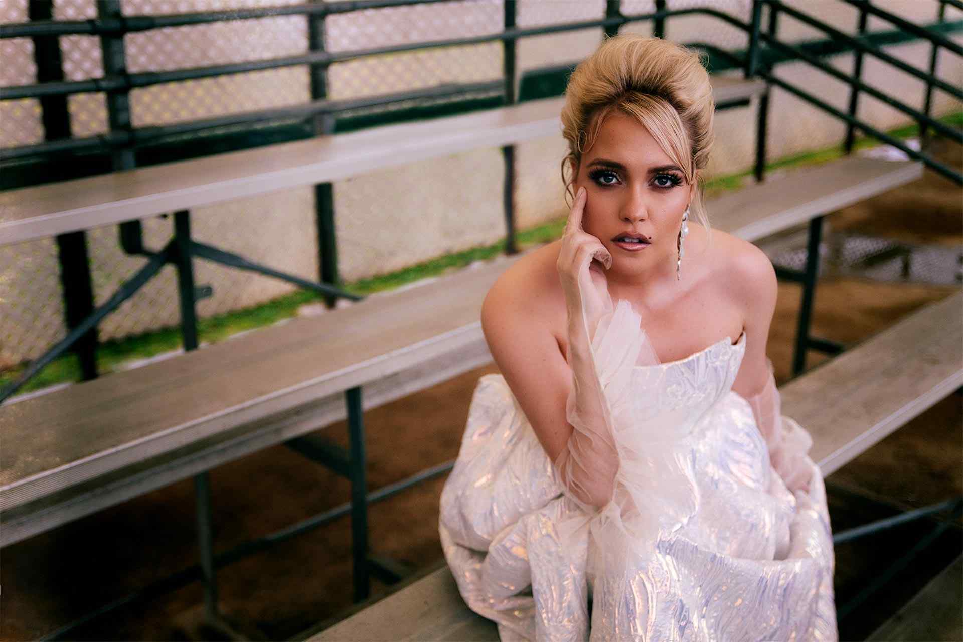 Eden sitting on bleachers in a prom dress