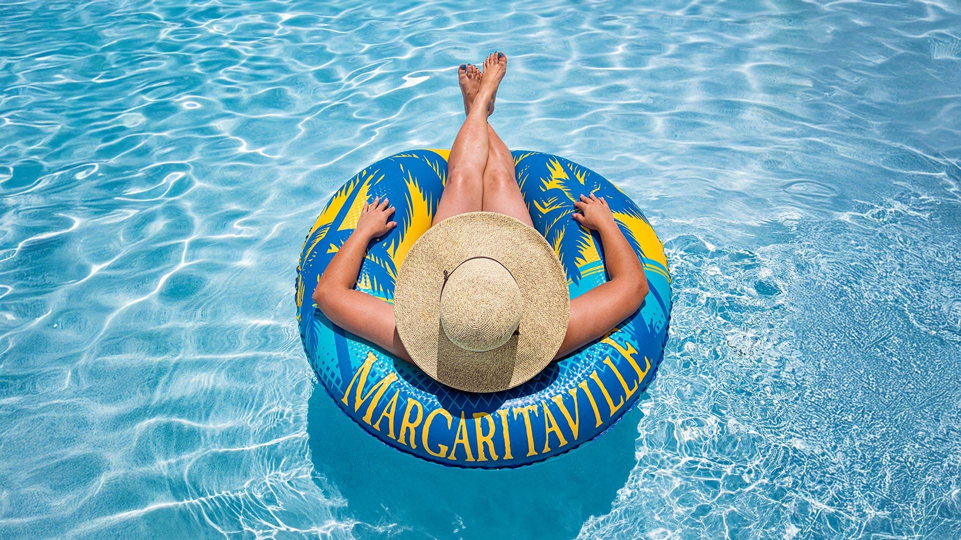 hero_1.jpg A woman sitting in a round pool innertube that has the word Margaritaville on it.