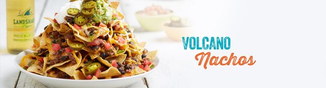 Volcano nachos piled high with chips, cheese, meat, tomatoes and jalapenos