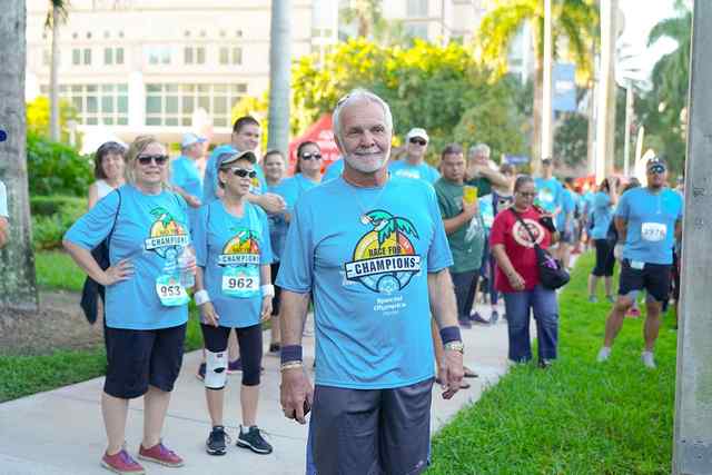 Four participants in Race for Champions smiling while holding a refreshment