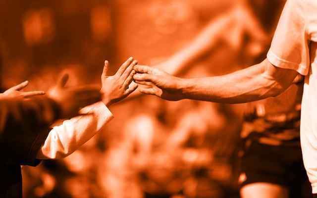 A runner touching the hands of other people with no faces showing