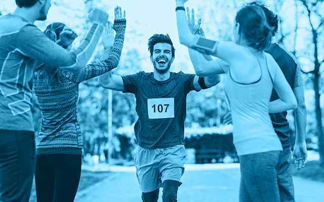 A runner giving high fives to 4 other people
