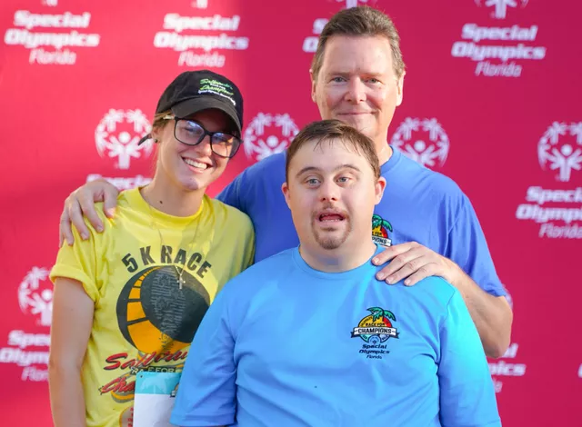 Four participants in Race for Champions smiling while holding a refreshment