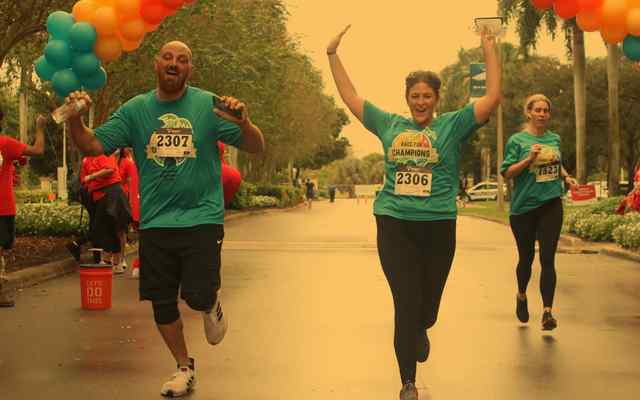 Large group of people putting their hands into the center of a circle