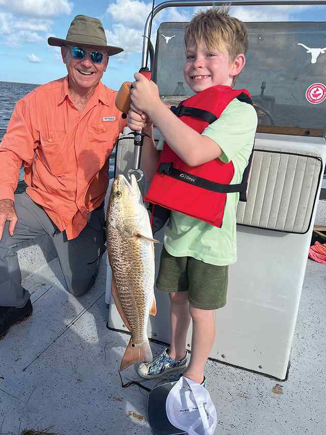 James Erickson with grandfather, Jim Wilkins Shoalwater Bay - 28" redfish CPR, caught on Bass Assassin Texas Roach