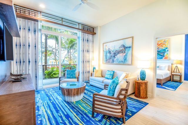 241112-MVNassauBeachResort-OPH-9210.jpg Resort suite living area leading to patio with tropical scenery